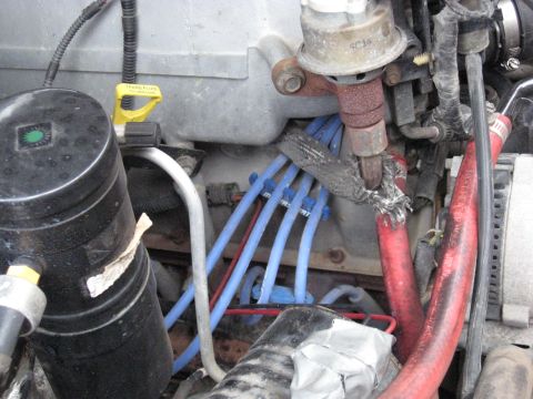 1994 Ford Bronco - Close-up view of an engine bay, showing spark plug wires and hoses. Text from a watermark is visible.