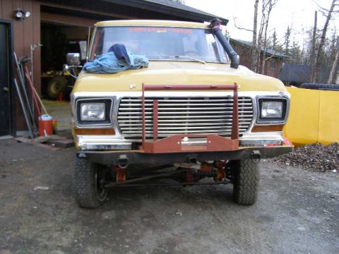 1978 Ford Bronco - The front of a yellow 1978 Ford Bronco is visible, equipped with a snorkel and a winch bumper.