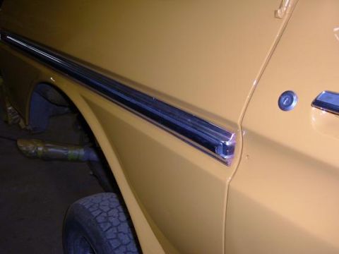 1978 Ford Bronco - Close-up of the side panel on a yellow 1978 Ford Bronco, highlighting the chrome trim.