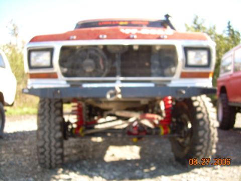 1978 Ford Bronco - A red and white 1978 Ford Bronco is shown from the front, with visible aftermarket modifications.