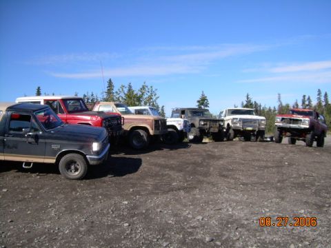 1978 Ford Bronco - A collection of SUVs and trucks are parked together outdoors under a clear blue sky.