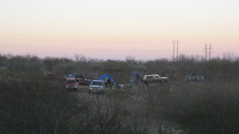 1979 Ford Bronco - A campsite scene with multiple vehicles and tents under a dusky sky.