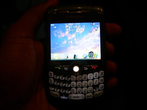 1992 Ford Taurus - A BlackBerry phone displays the date and time on its screen, held by a person's hand.