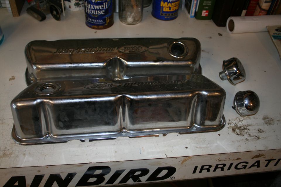 Pair of polished aluminum Ford valve covers on a workbench