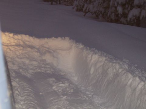 1986 Ford Bronco - A snow-covered scene shows tire tracks leading through a deep snow bank.