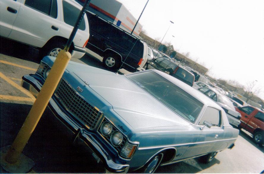 Light blue 1974 sedan parked in a lot, front grille and headlights visible