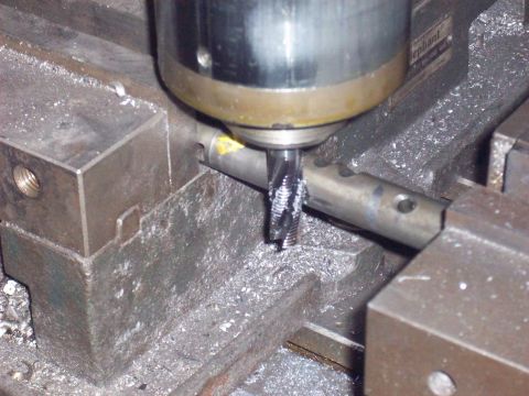 1978 Ford Bronco - A milling machine is actively cutting a metal rod, creating metal shavings.