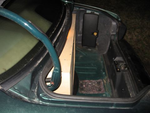 1992 Ford Crown Victoria - The trunk of a car shows a custom-built subwoofer enclosure taking up significant space.