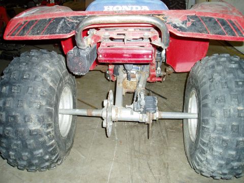 2000 Ford E350 - The rear of a red Honda ATV is shown, with its large tires and metal frame visible.