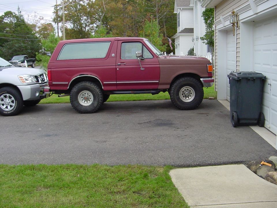 Side view of a 1991 Ford Bronco, maroon with brown front fender