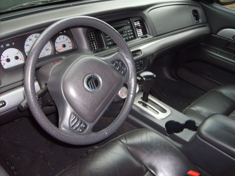Gray Mercury sedan interior with steering wheel, gauges, and automatic shifter