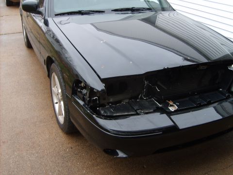 1993 Ford Crown Victoria - Front view of a black 1993 Ford Crown Victoria showing damage to the grille and headlight area.