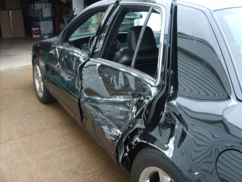 1993 Ford Crown Victoria - The driver's side of the vehicle sustained heavy impact, crumpling the doors and body panels.
