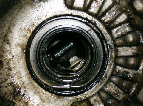 1995 Ford Probe - Close-up view of a worn bearing within a greasy mechanical housing, showing signs of wear and tear.