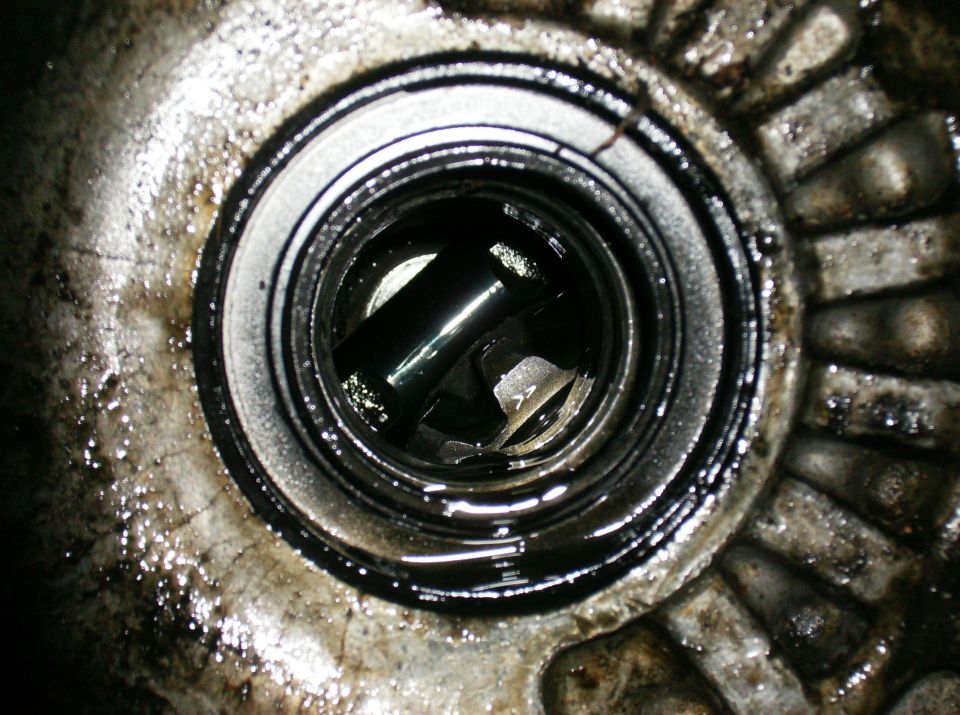 Greasy mechanical part with a shaft visible inside a circular opening