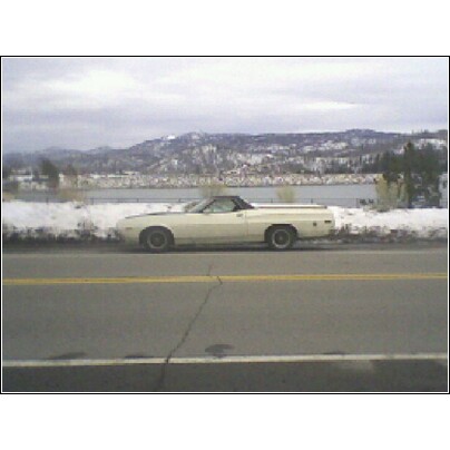 1972 Ford Ranchero - A 1972 Ford Ranchero is seen parked on the side of a road with a snowy mountain range in the distance.