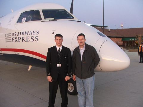 1989 Ford Bronco - A pilot and a passenger stand in front of a US Airways Express airplane.