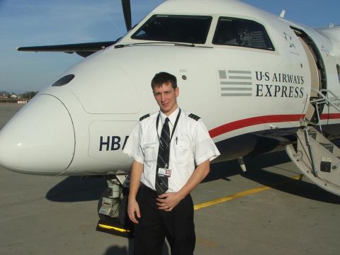 1989 Ford Bronco - Pilot poses in front of a U.S. Airways Express aircraft on the tarmac.