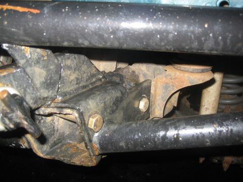 1995 Ford Bronco - Close-up view of the rusty undercarriage of a vehicle, showing suspension components.