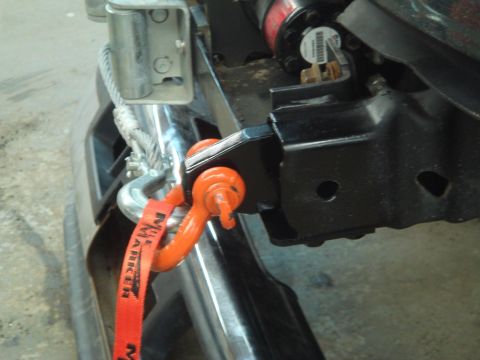 1996 Ford Bronco - Close-up of a winch, orange shackle, and red tow strap connected to a vehicle's frame.