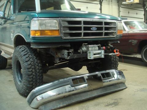 1996 Ford Bronco - Front view of a 1996 Ford Bronco undergoing winch installation, with its bumper detached.