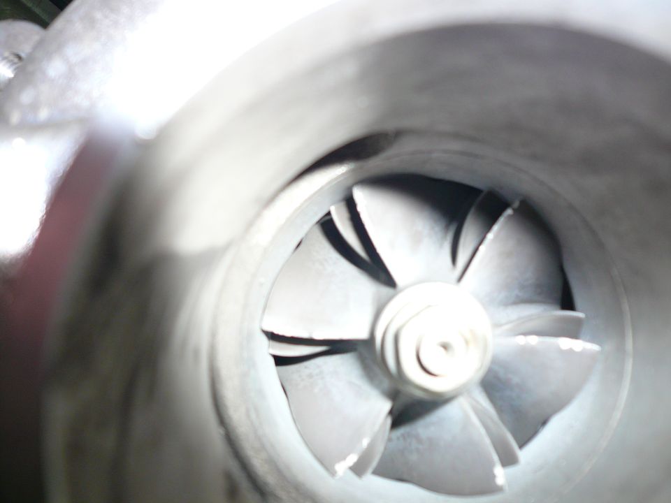 Turbocharger compressor wheel with angled blades, close-up view