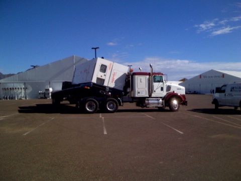 1994 Ford Bronco - A tractor-trailer truck transports a large generator, with a white van visible in the background.