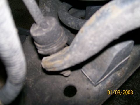 1995 Mercury Grand Marquis - Close-up of a front sway bar end link and bracket, with a date stamp and SuperMotors logo.