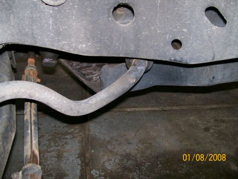 1995 Mercury Grand Marquis - A close-up view of a vehicle's front sway bar and associated suspension parts, showing wear and tear.