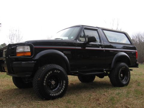 1967 Ford Mustang - This black Ford Bronco is shown from a three-quarter front view, parked outdoors on a grassy area.