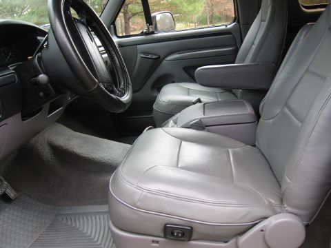 1967 Ford Mustang - The interior of a truck shows gray leather seats, dashboard, and steering wheel.