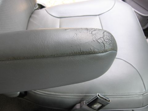 1967 Ford Mustang - Cracked armrest on a car seat shows significant wear.