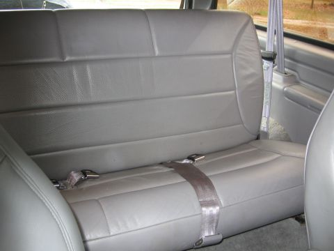 1967 Ford Mustang - The gray leather rear seat and seatbelts are visible in this interior shot.