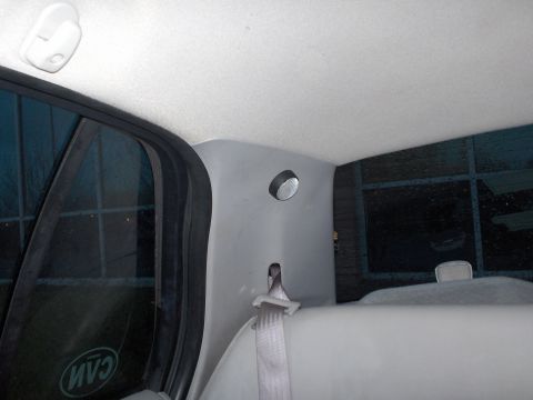 2001 Ford Crown Victoria - Interior view of a car's rear pillar and window, showing a seatbelt and a light.