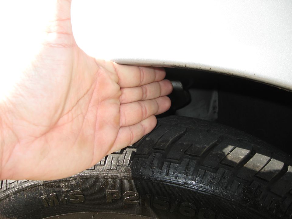 Hand showing clearance above a tire. Text on tire reads M+S P2