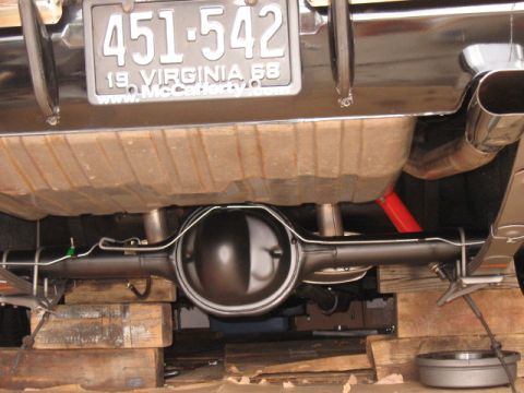1968 Shelby GT500 - Close-up of a car's rear axle and suspension components, with a Virginia 1968 license plate visible.