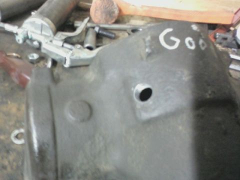 1992 Ford F-350 - A metal automotive part is shown with a grease gun and tools in a workshop setting.