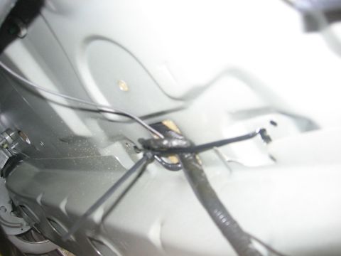 2000 Ford Crown Victoria - Close-up view of a vehicle's underbody wiring harness, showing taped connections and metal components.