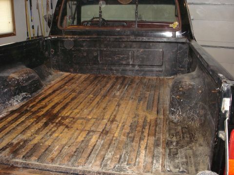 1979 Ford F-150 - The wooden bed of a black 1979 Ford F-150 Explorer shortbed shows significant wear and tear.