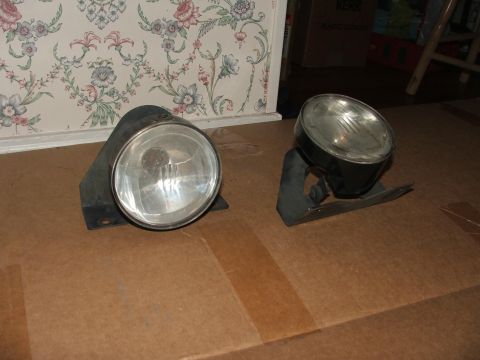1991 Ford Crown Victoria LTD - Two headlights are displayed on a cardboard surface, with floral wallpaper in the background.
