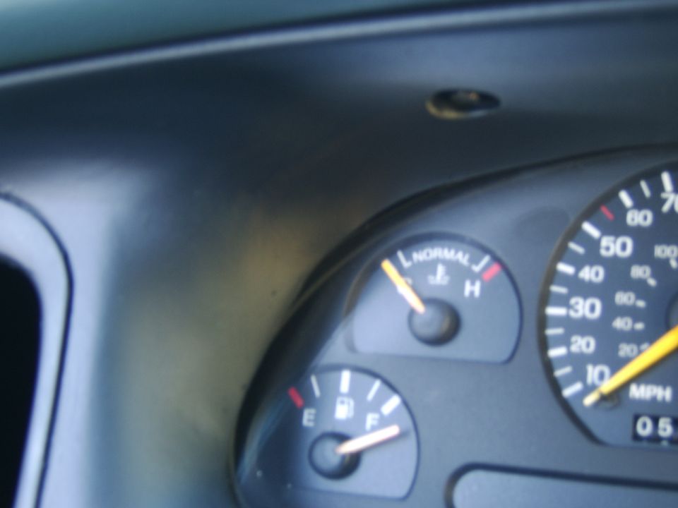 Car instrument cluster with temp, fuel, and speedometer gauges