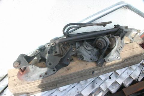 1991 Ford Bronco - Assorted suspension parts are piled on a wooden pallet, likely for a vehicle modification.