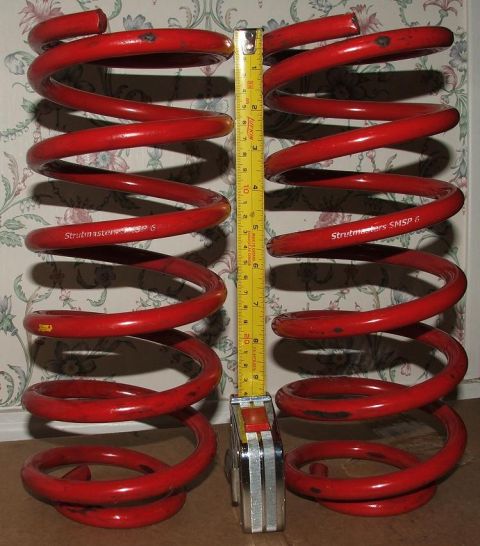 1991 Ford Crown Victoria LTD - A tape measure is shown next to two red coil springs, indicating their size.