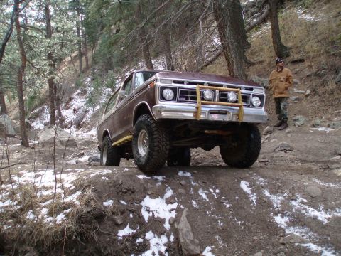1979 Ford Bronco - This 1978 Ford Bronco navigates a challenging off-road path with snow patches on the ground.