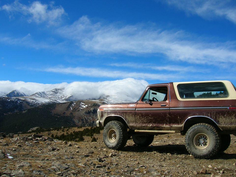 Brown 1979 Ford Bronco parked on a rocky mountain overlook