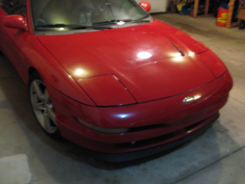 1993 Ford Probe - The front quarter view of a red 1993 Ford Probe shows its distinctive pop-up headlights and alloy wheels.