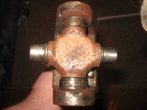 1979 Ford Bronco - A rusty universal joint is held in a hand, showing wear and tear.