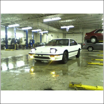 1994 Ford F-250 - A white 1988 Honda Prelude is parked in a garage, with other vehicles on lifts in the background.