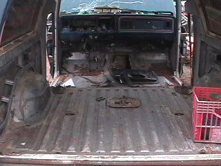 1979 Ford Bronco - The interior of a 1979 Ford Bronco shows a dismantled dashboard and an empty cargo bed.