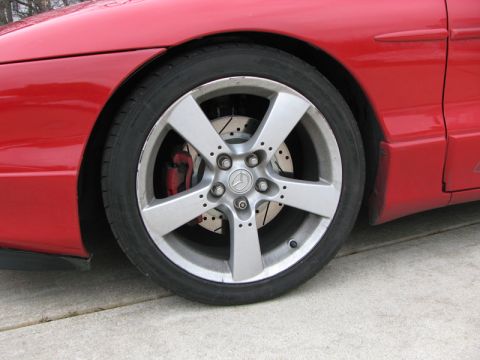 1993 Ford Probe - Close-up of a red car's wheel, aftermarket rims and drilled brake rotors.